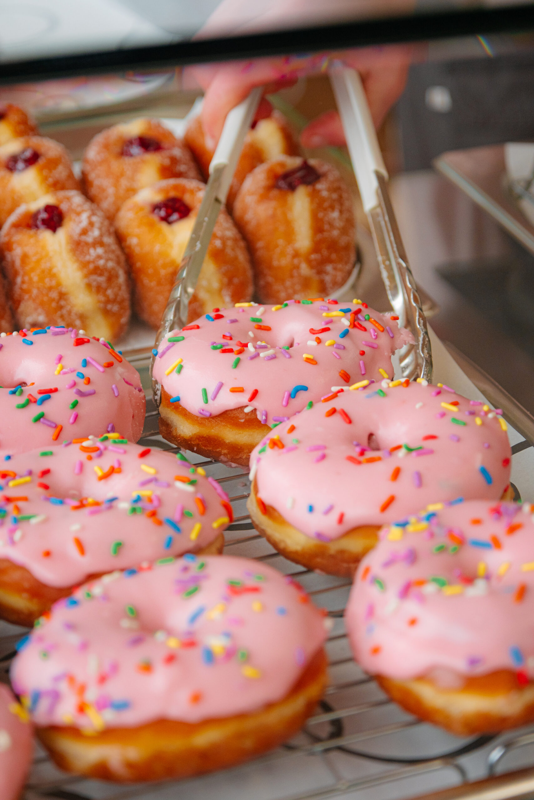 A close up of some pink icing doughnuts from Proven Goods