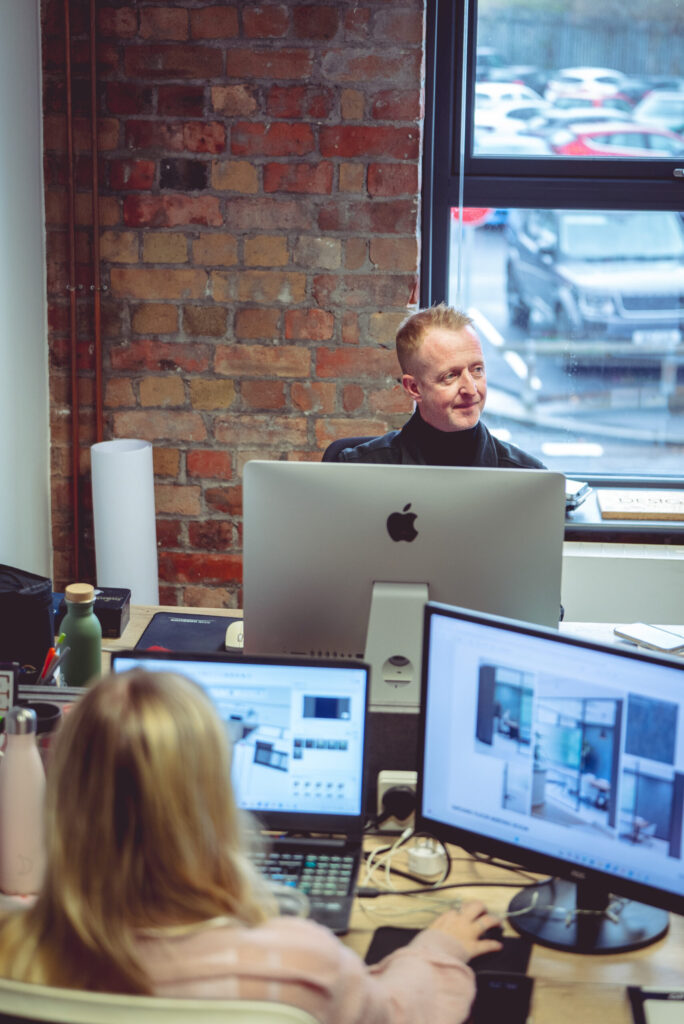 image shows people working at their desk